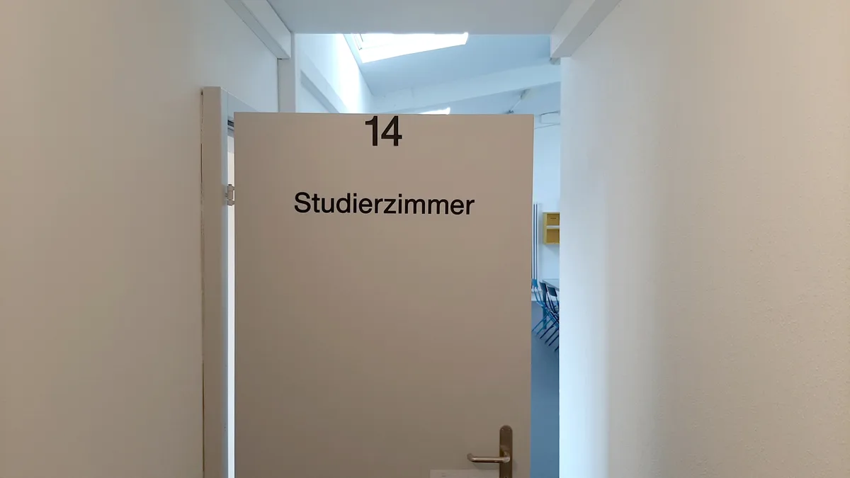 Eine geöffnete Tür mit der Aufschrift «Studierzimmer».